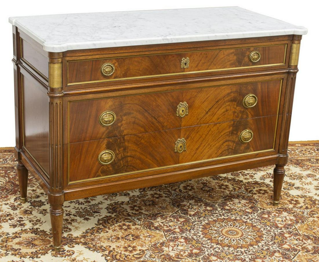 FRENCH LOUIS XVI STYLE MARBLE-TOP MAHOGANY COMMODE: French Louis XVI style mahogany commode, late 19th c., rectangular marble top, fluted sides, case fitted with three drawers, urn and wreath-form escutcheons and pulls, on tapered legs, terminating in 