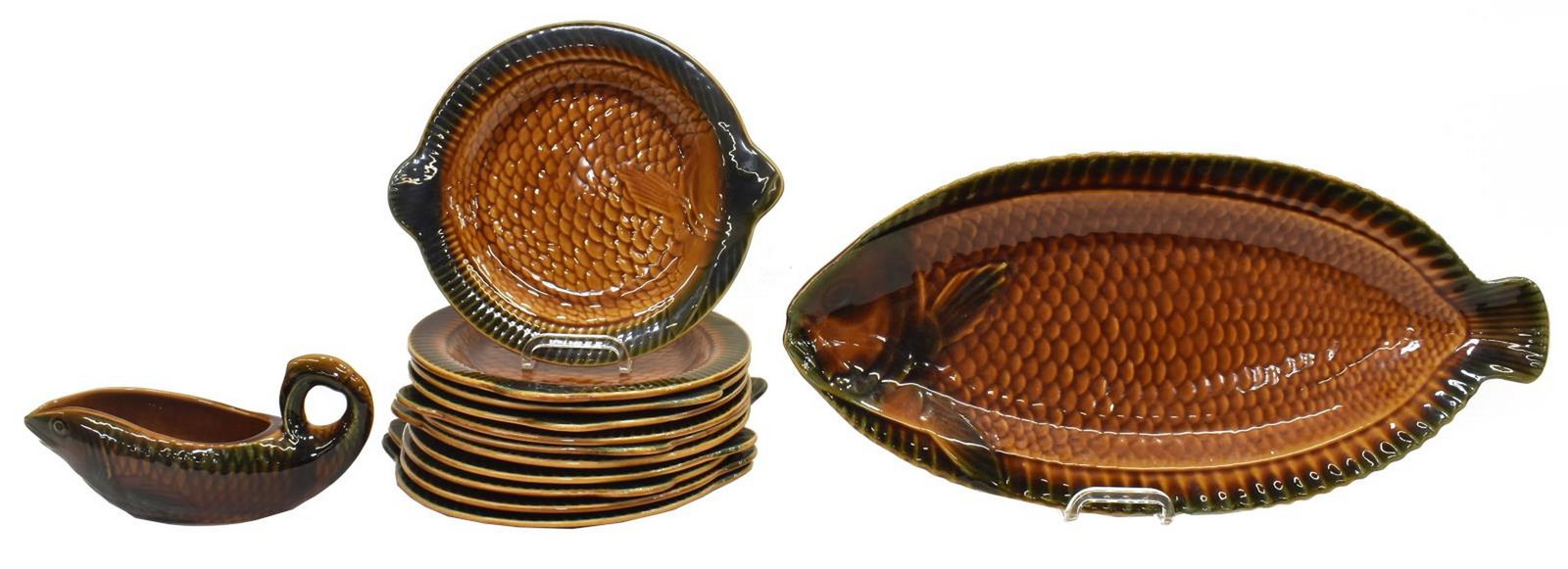 (13) FRENCH SARREGUEMINES SEAFOOD SERVICE: (lot of 13) French seafood service, mid 20th c., modeled in the form of a fish, in mottled brown/ orange and green glazes, marked Sarreguemines France underfoot, comprising: (11) plates, approx 10.75"