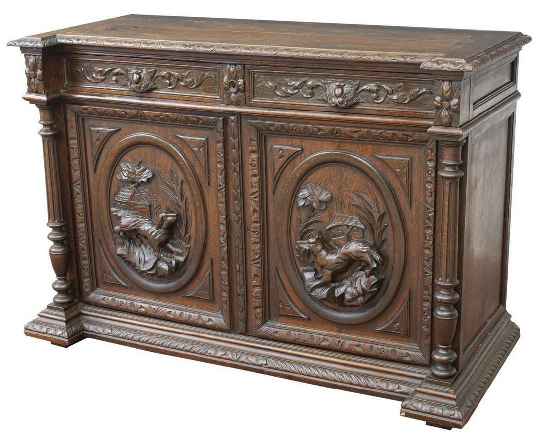 FRENCH HENRI II STYLE CARVED OAK HUNT SIDEBOARD: French Henri II style oak hunt board, 19th c., with lunette molding, two drawers over double-door cabinet, doors with hunting dog and fox in relief, interior shelf, fluted column uprights, plinth base