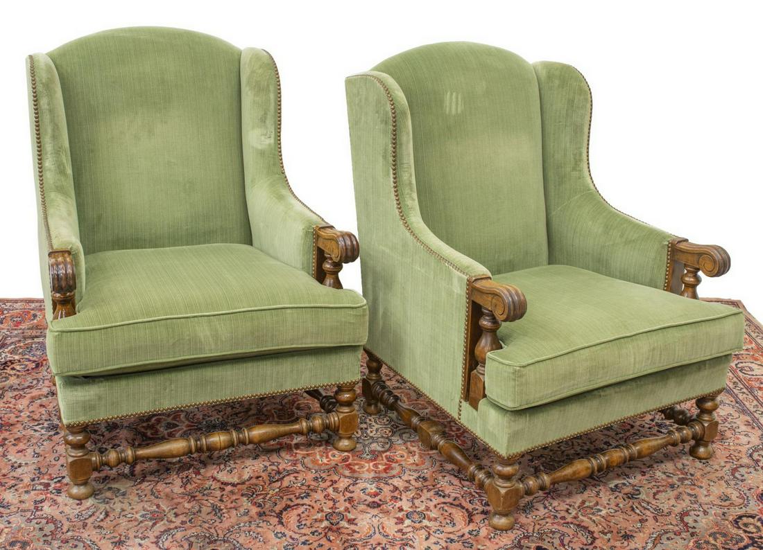 (2) FRENCH LOUIS XIII STYLE WINGBACK BERGERES: (pair) French Louis XIII style walnut armchairs, 19th c., in green upholstery, with nailhead borders, arms terminating in carved scroll handholds, rising on turned stretcher-joined legs, ending in bun