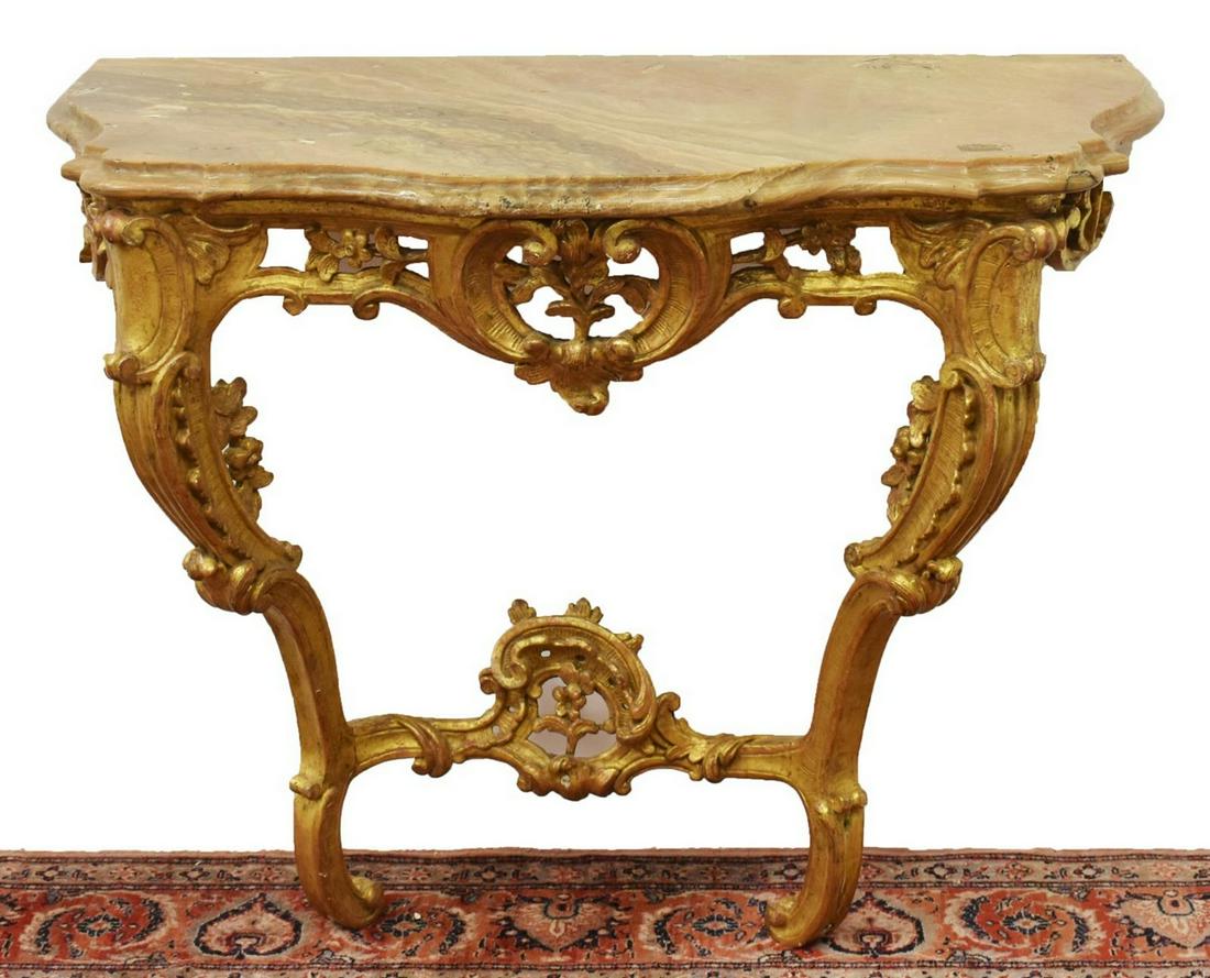 LOUIS XV STYLE GILTWOOD CONSOLE WALL BRACKET: Louis XV style giltwood console table, having a shaped stone top, likely onyx, over gilt bracket with relief carved foliate and shell accents, cabriole legs joined by floral carved stretcher, some fil