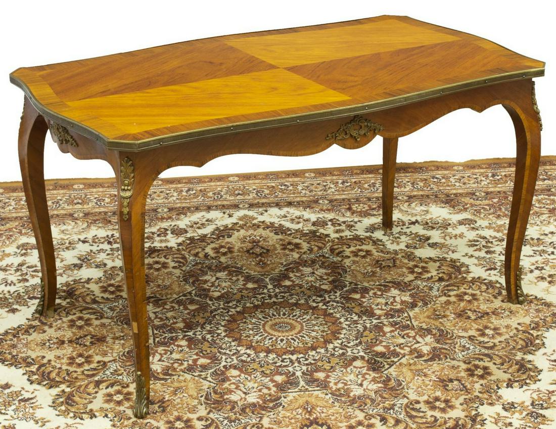 LOUIS XV STYLE METAL-MOUNTED COFFEE TABLE: Louis XV style gilt metal mounted coffee table, 20th c., having a shaped tabletop, over a scalloped apron, featuring gilt metal foliate mounts, rising on cabriole legs, ending in sabots, approx 22.75"