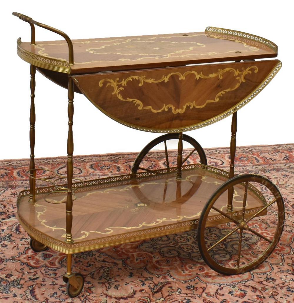 ITALIAN DROP-LEAF MARQUETRY SERVICE CART TROLLEY: Italian drop-leaf marquetry service cart, mid 20th c., having a metal handle and pierced gallery enclosing upper and lower tiers, featuring contrasting and colored marquetry, lower tier fitted with tr