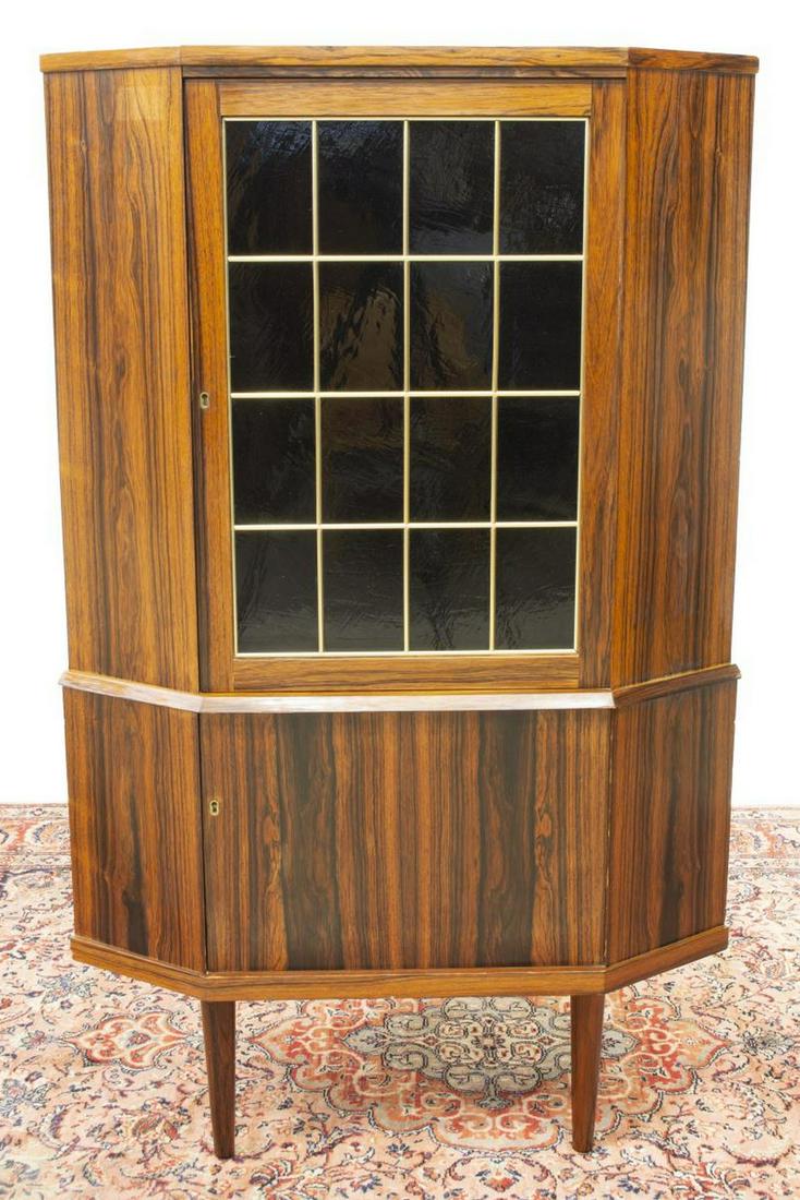 DANISH MID-CENTURY MODERN ROSEWOOD CORNER CABINET: Danish mid-century modern rosewood corner cabinet, c.1960s, upper and lower cabinets fitted with shelved interior, upper glazed door, rising on tapered legs, approx 55"h, 33.5"w, 24"d Start Price: $20
