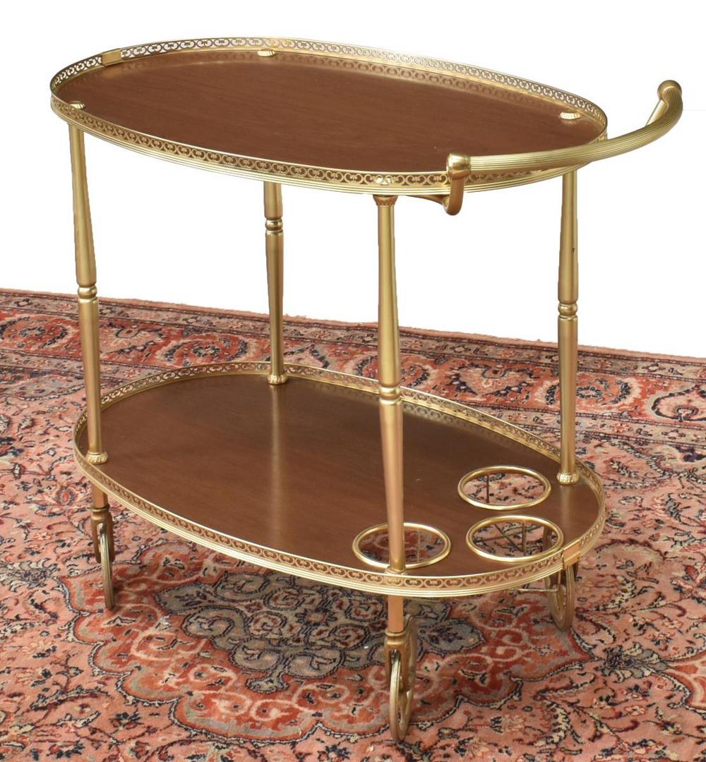 ITALIAN MODERN GILT METAL SERVICE BAR CART: Italian mid-century modern gilt metal service cart, c.1960s-1970s, having pierced gallery, inset wood trays, three bottle holders on lower tier, turned supports, on wheels, approx 29"h, 32.25"w, 18"d 