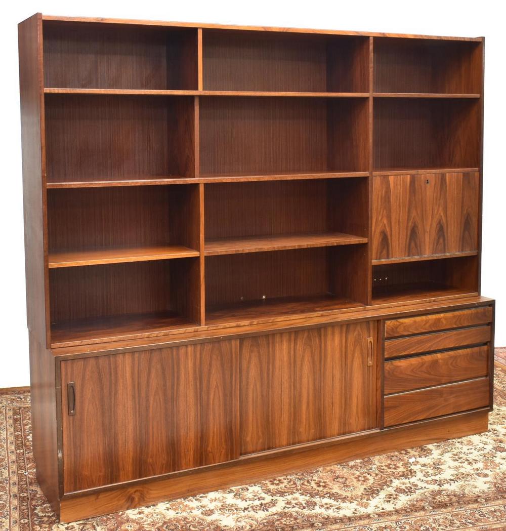 DANISH MID-CENTURY MODERN ROSEWOOD WALL UNIT: Danish mid-century modern rosewood bookcase, c.1960s, having open display shelves, drop-front bar cabinet opening to mirrored interior, lower sliding doors, opening to additional interior shelves, all