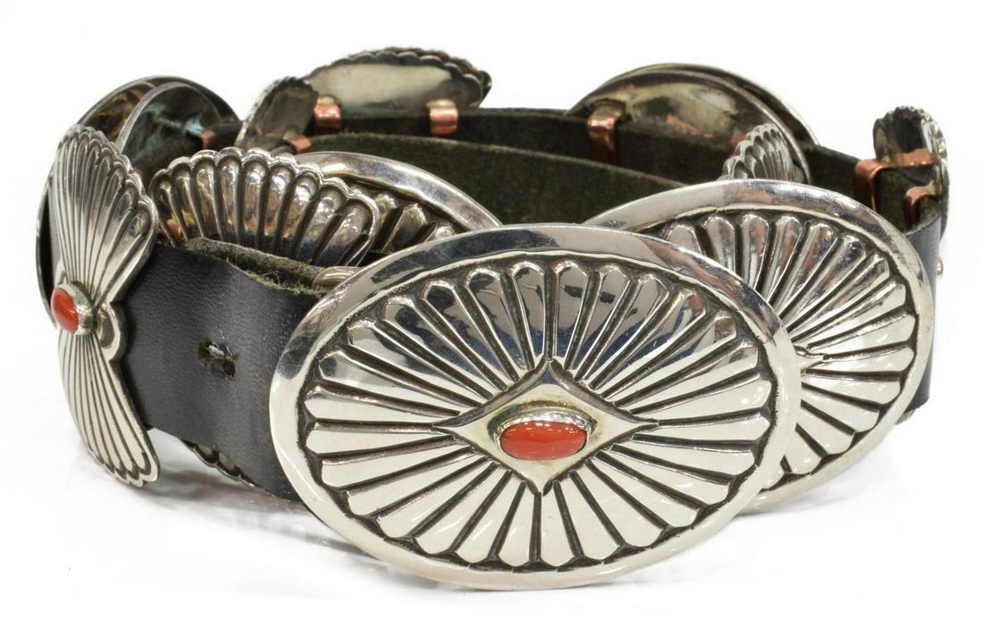 LEON MARTINEZ NAVAJO STERLING & CORAL CONCHO BELT: Native American concho belt, Leon Martinez (Navajo, 20th c.), sterling silver buckle, six oval conchos, seven bow tie spacers, each with a bezel-set red coral cabochon, black leather belt, belt: appro