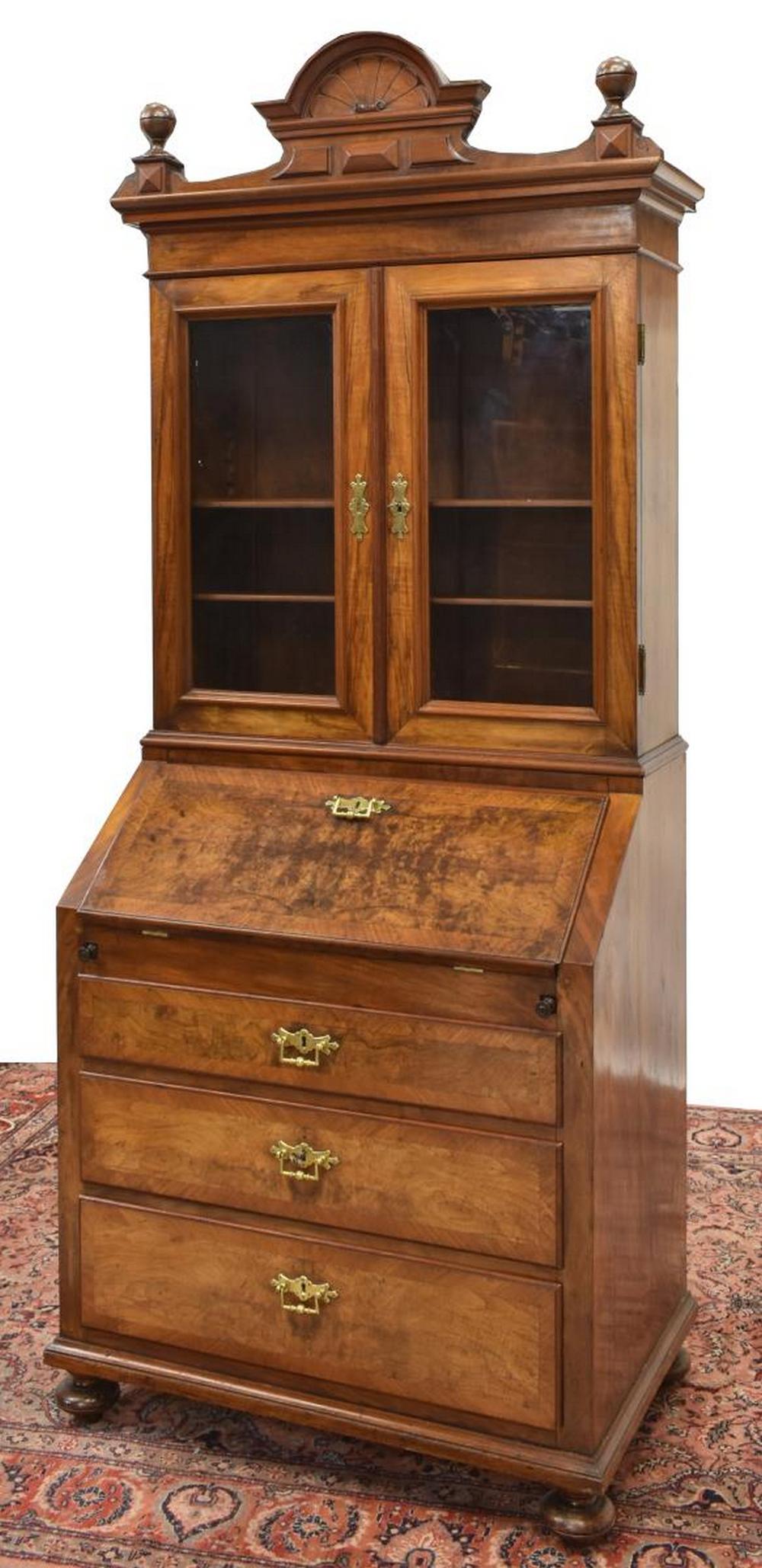 DANISH SECRETARY BOOKCASE, 19TH C.: Danish secretary bookcase, 19th c., turned finials and carved crest surmounting molded cornice, upper case fitted with glazed double doors, opening to shelved interior, over slant-front desk, revealin