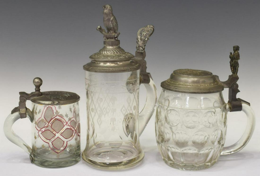 (3) GERMAN CLEAR GLASS BEER STEINS: (lot of 3) German beer steins/ mugs, including: (1) clear etched glass with thumbprint decoration, the applied handle with pierced pewter thumb rest, the pewter lid with a bird at top and old German s