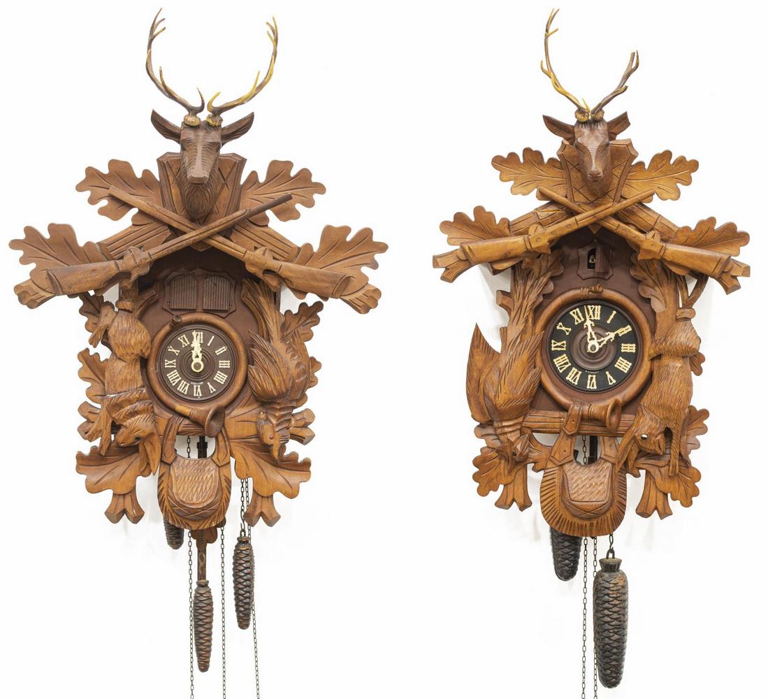 (2) GERMAN BLACK FOREST CARVED CUCKOO CLOCKS: (lot of 2) German Black Forest cuckoo clocks, 20thc., each in carved case featuring game animals and foliates, with white Roman numerals to black clock face, retaining pine cone weights, comprising: (