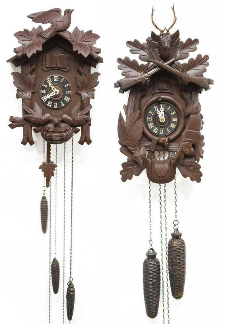 (2) GERMAN BLACK FOREST CARVED CUCKOO CLOCKS: (lot of 2) German Black Forest cuckoo clocks, 20thc., each in dark finish, carved case featuring game animals and foliates, with white Roman numerals to black clock face, retaining pine cone weights, 