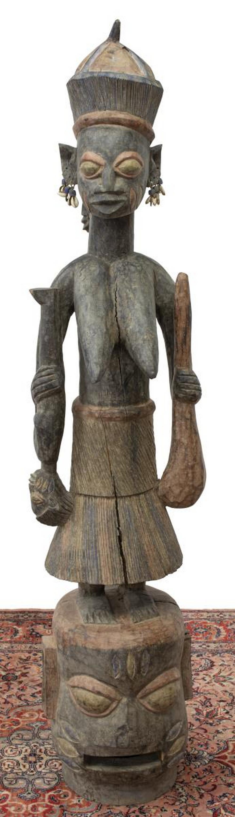AFRICAN YORUBA CARVED WOOD MATERNITY FIGURE 68"H: African tribal carved wood maternity figure,Yoruba People, Nigeria, female figure with cowrie shell earrings, holding two children, standing on double-sided mask plinth, remnants of polychrome pigment