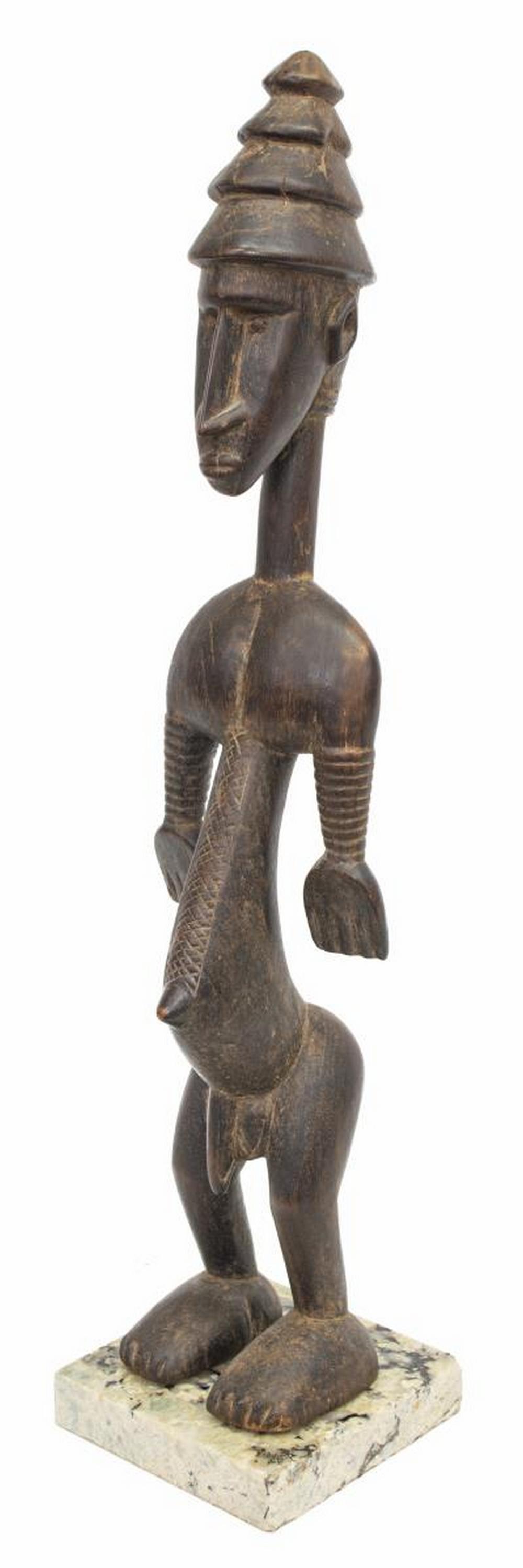 AFRICAN BAMBARA CARVED WOOD FIGURE, 26"H: Bambara carved wood figure, West Africa, likely Mali, a male figure with conical hat, approx. 26"h, 5.5"w, 4"d, rising on a 1.25"h, 6"w, 6"d marble base, total: 7.90lbs Start Price: $80.00