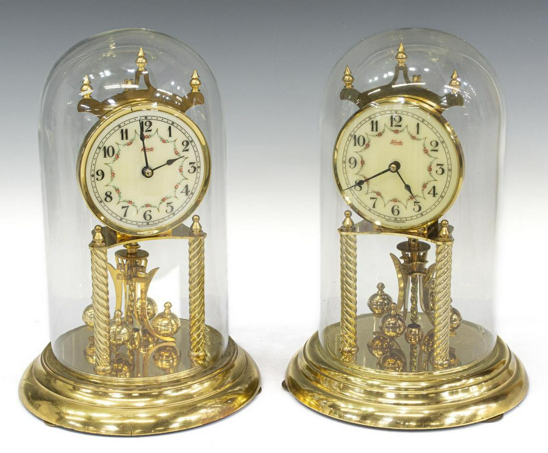 (2) GERMAN KUNDO GILT METAL ANNIVERSARY CLOCKS: (lot of 2) German gilt metal torsion pendulum/ anniversary clocks, mid to late 20th c., fancy style dial with Arabic numerals, marked Kundo, under glass cloches/ domes, including: (1) with movement by