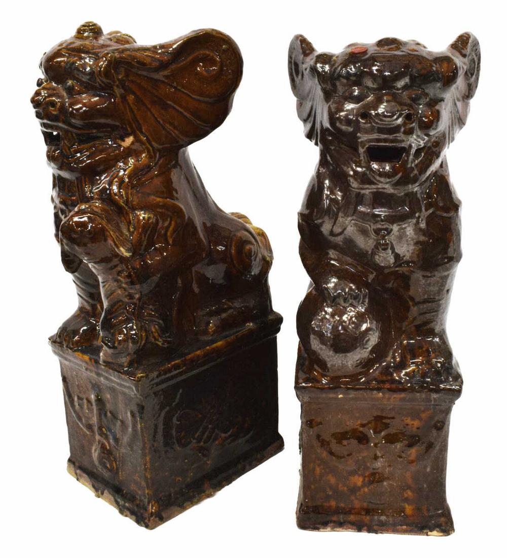 (2) LARGE CHINESE BROWN GLAZED FOO DOG FIGURES: (pair) Large Chinese porcelain Foo Dogs, each glazed brown, with detailed features and large ears, rising on pedestal base, (one) with ball positioned beneath front paw, (one) with young Foo-Dog at fe