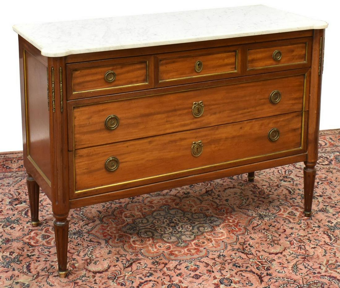 FRENCH LOUIS XVI STYLE MARBLE-TOP MAHOGANY COMMODE: French Louis XVI style mahogany commode, early 20th c., having a marble top, over case fitted with three drawers, flanked by fluted columns, gilt metal accents, rising on fluted tapered legs, approx 3
