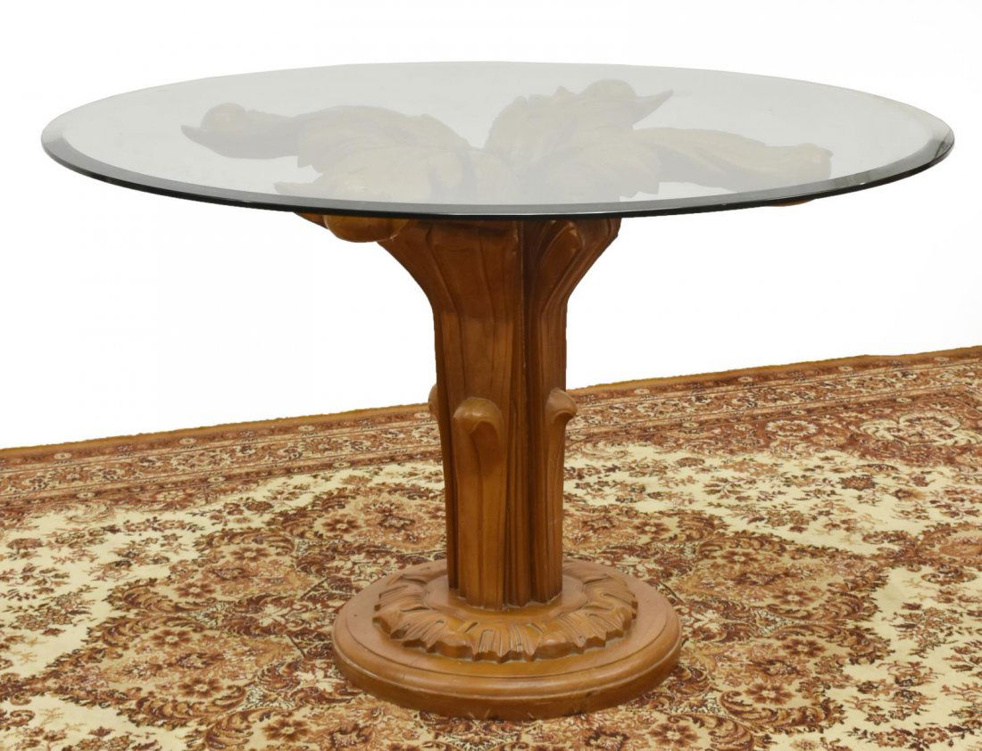 FRENCH GLASS-TOP CARVED FRUITWOOD CENTER TABLE: French carved fruitwood center table, 20th c., having a circular glass top with beveled edge, over heavily foliate carved pedestal base, loss and restoration to top of base, approx 29.5"h, 47.5"w, 22"