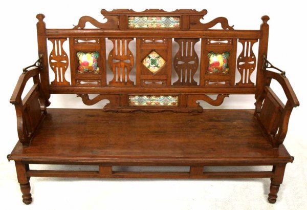 ANTIQUE CARVED TEAKWOOD MAJOLICA RAILROAD BENCH: Antique Anglo-Indian teakwood railway bench set with majolica tiles, the well carved, pierced backrest reversible as it swivels on brass hinges, bench seat rising on turned supports, restoration, 37"h