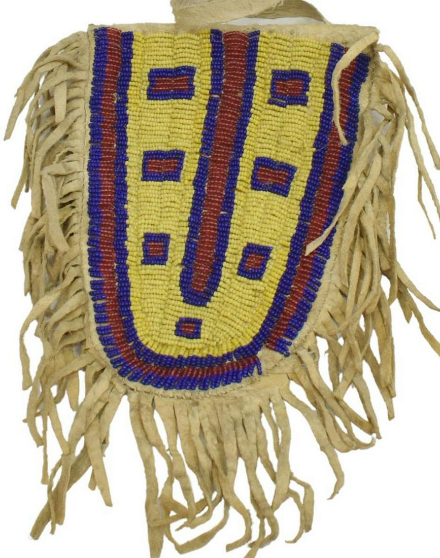SIOUX BEADED HIDE FRINGE POUCH, C.1890-1910: Native American beaded hide pouch, Sioux, c.1890-1910, decorated only on one side, strap, approx 7"l, 5"w (exclusive of fringe), 0.25lbs Start Price: $150.00