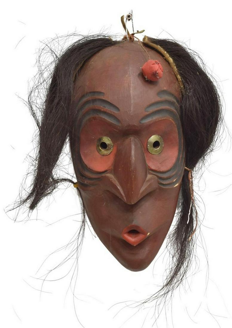 IROQUOIS CARVED WOOD FALSE FACE MASK, C.1940-1960: Native American carved wood False Face mask, Iroquois, c.1940-1960, reddish-brown paint, black stripes around eyes, red at eyes and lips, small medicine bag, horse hair, approx 12.5"h, 6.5"w, 4.25"d, 