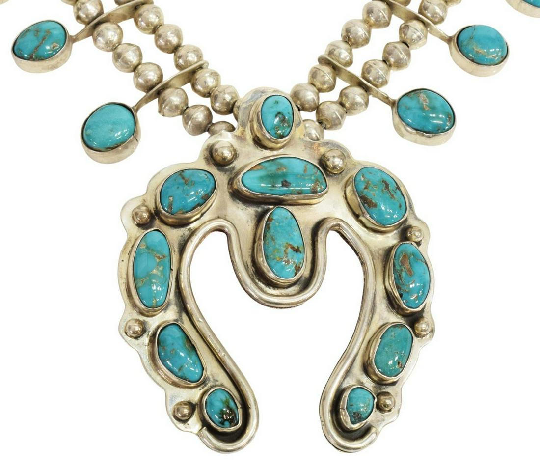 NAVAJO BLUE GEM TURQUOISE SQUASH BLOSSOM NECKLACE: Native American silver (content unknown) squash blossom necklace, likely Navajo/ Dine, with Blue Gem turquoise, fourteen blossoms each set with a turquoise cabochon, large central naja with turquoise,