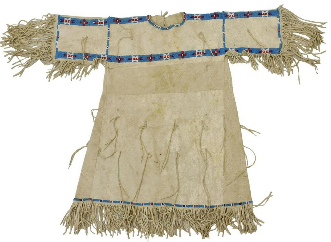 CENTRAL PLAINS BEADED HIDE GIRL'S DRESS, C.1925: Native American beaded hide girl's dress, Central Plains, c.1910-1925, beaded bodice and hem, fringe, sleeves: approx 8"l (exclusive of fringe), collar to hem: approx 27"l (exclusive of fringe), 3lbs 
