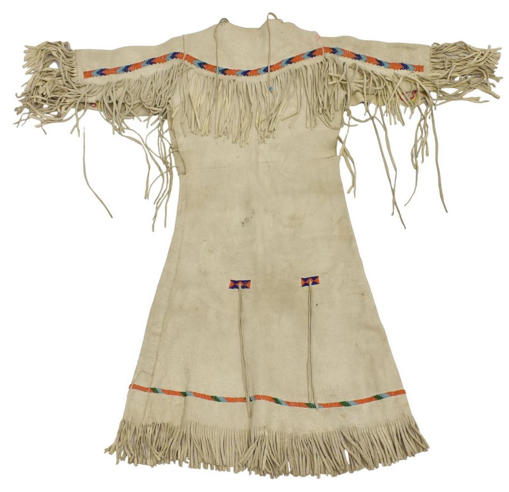 PLAINS BEADED HIDE GIRL'S DRESS, C.1930-1950: Native American beaded hide girl's dress, Plains, c.1930-1950, fringe, sleeves: approx 10.5"l (exclusive of fringe), collar to hem: approx 35"l (exclusive of fringe), 1.75lbs Start Price: $150.00