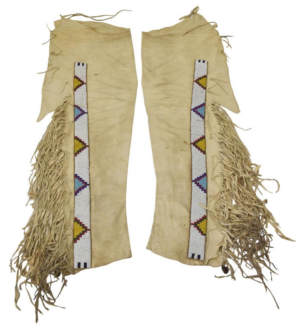 NORTHERN PLAINS HIDE LEGGINGS, C.1900-1920: Native American hide leggings, Northern Plains, c.1900-1920, long fringe, bells over foot end, slight moth or rub damage, approx 36"l, 12.5"w, 2.25lbs Start Price: $300.00