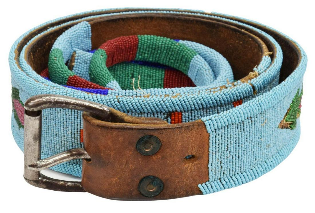BLACKFOOT OR NEZ PERCE BEADED LEATHER BELT, C.1915: Native American beaded leather belt, Blackfoot or Nez Perce, c.1895-1915, with split tab beaded drops, belt section: approx 46"l (including buckle), two drops: approx 26"l; 1lbs total Start Price: $15