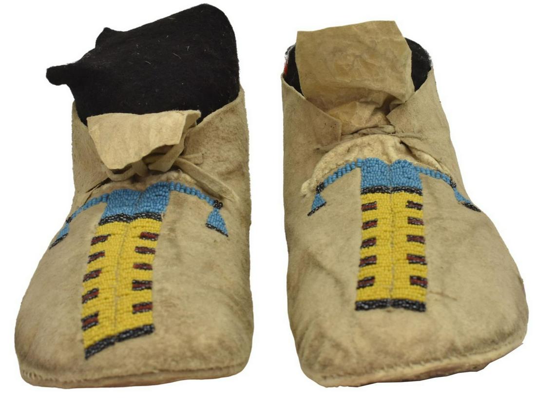 CENTRAL PLAINS BEADED HIDE MOCCASINS, C.1890-1910: Native American beaded hide moccasins, Central Plains, c.1890-1910, tagged: "museum deaccession, c.1880s, probably Southern Arapaho," approx 10"l, 0.75lbs Start Price: $200.00