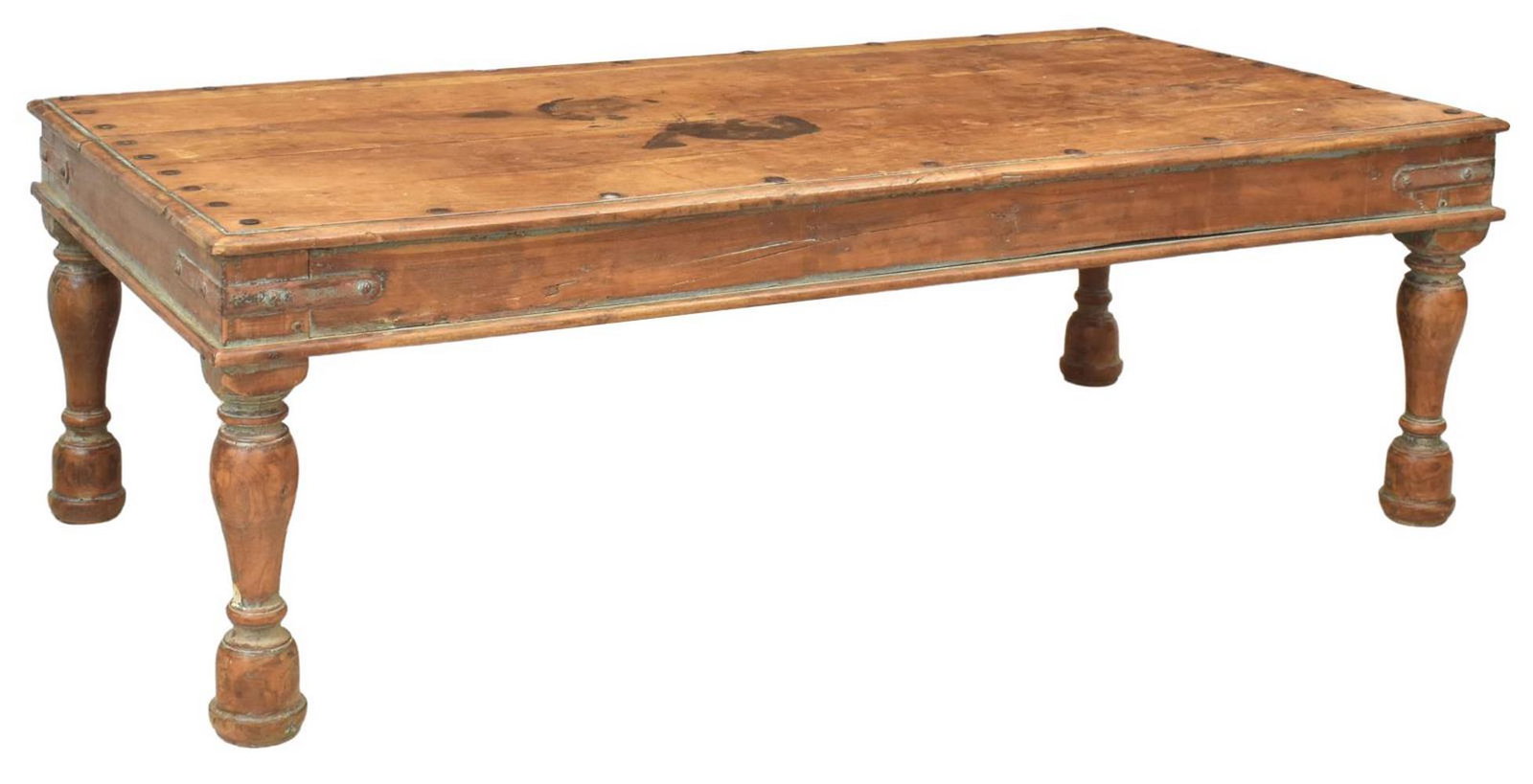 LARGE RUSTIC OAK & IRON ACCENTED COFFEE TABLE: Large rustic oak coffee table, with visible nailhead trim and iron hardware, on large turned supports, with natural textures to wood, loss to one corner, large stain to tabletop, approx 22"h, 67.5"w, 
