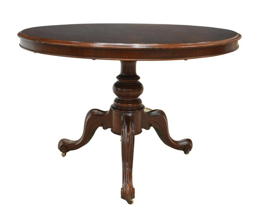 LATE VICTORIAN MAHOGANY TILT-TOP CENTER TABLE: Late Victorian mahogany tilt-top center table, early 20th c., circular tabletop, turned center pedestal with drop finial, three scrolled legs, on casters, approx 28"h, 42"diam, top up: approx 52.5"h *