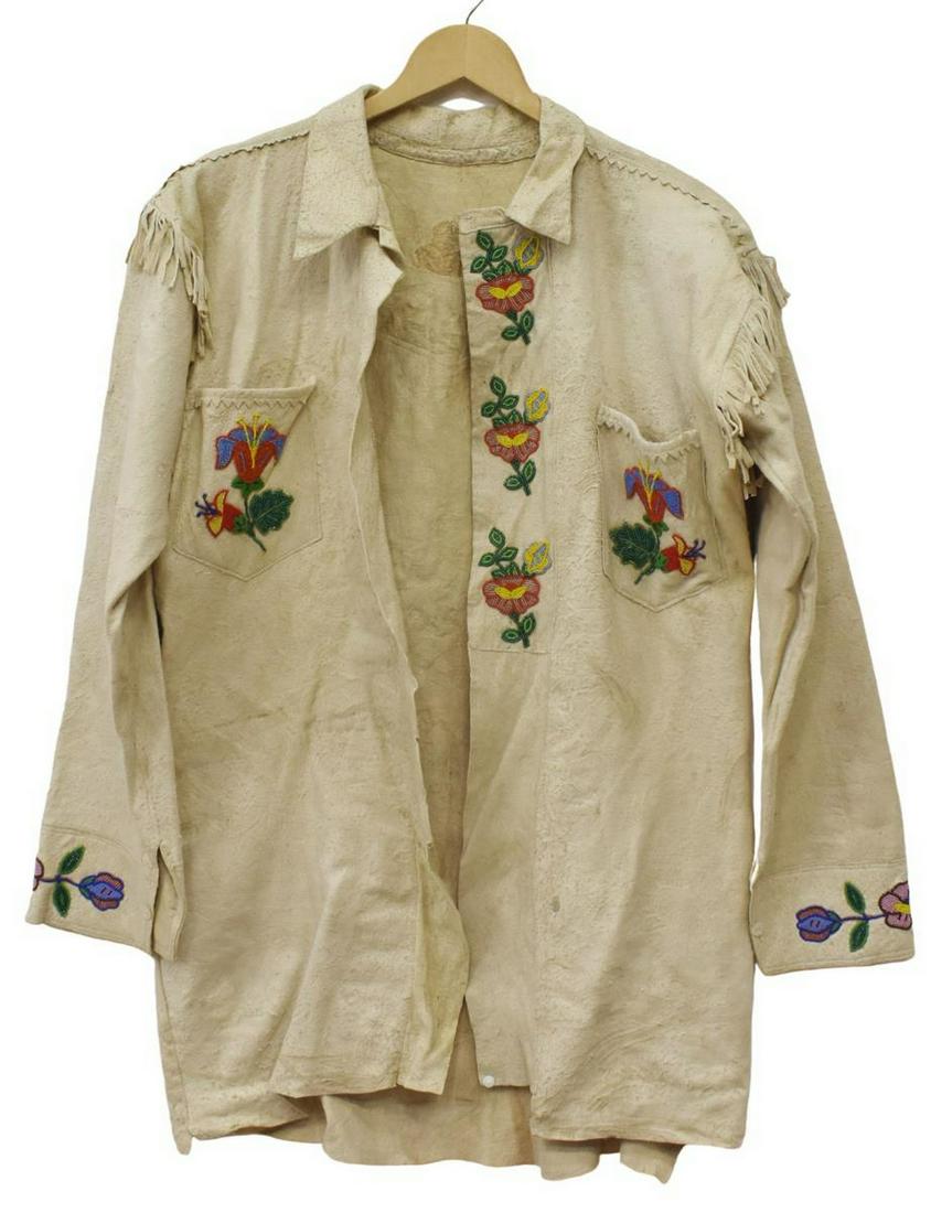 CREE BEADED HIDE FRINGE JACKET, C.1920-1940: Native American beaded hide jacket, Cree, c.1920-1940, partial-bead and fringe decoration, sleeves: approx 22"l, collar to hem: approx 31"l, 1.75lbs Start Price: $100.00