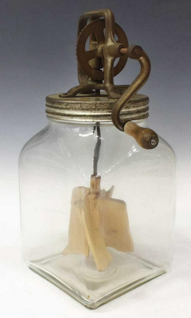 VINTAGE SIX-QUART GLASS JAR BUTTER CHURN: Vintage butter churn, early 20th c., with cast iron hand crank churn, wooden paddles, six-quart colorless glass jar, approx 15"h, 6.75"w, 6.75"d, 7lbs **Provenance: Eight Point Ranch, Elgin, Texas** S