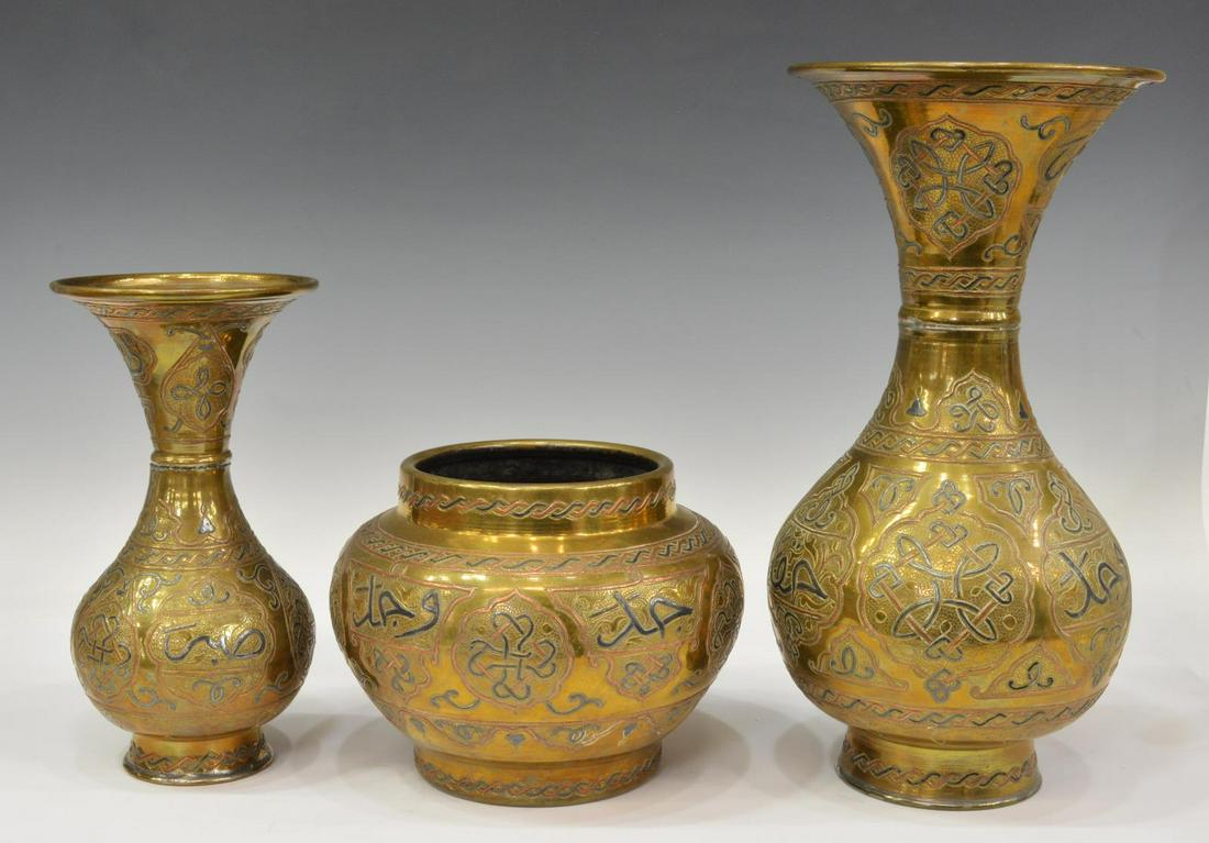 (3) ISLAMIC MIXED METAL INLAID BRASS VASES & URN: (lot of 3) Islamic brass vases, with mixed metal inlays, varied sizes and forms including: (2) with flared rim and (1) of squat form, each decorated throughout with arabesques and calligraphic motifs,