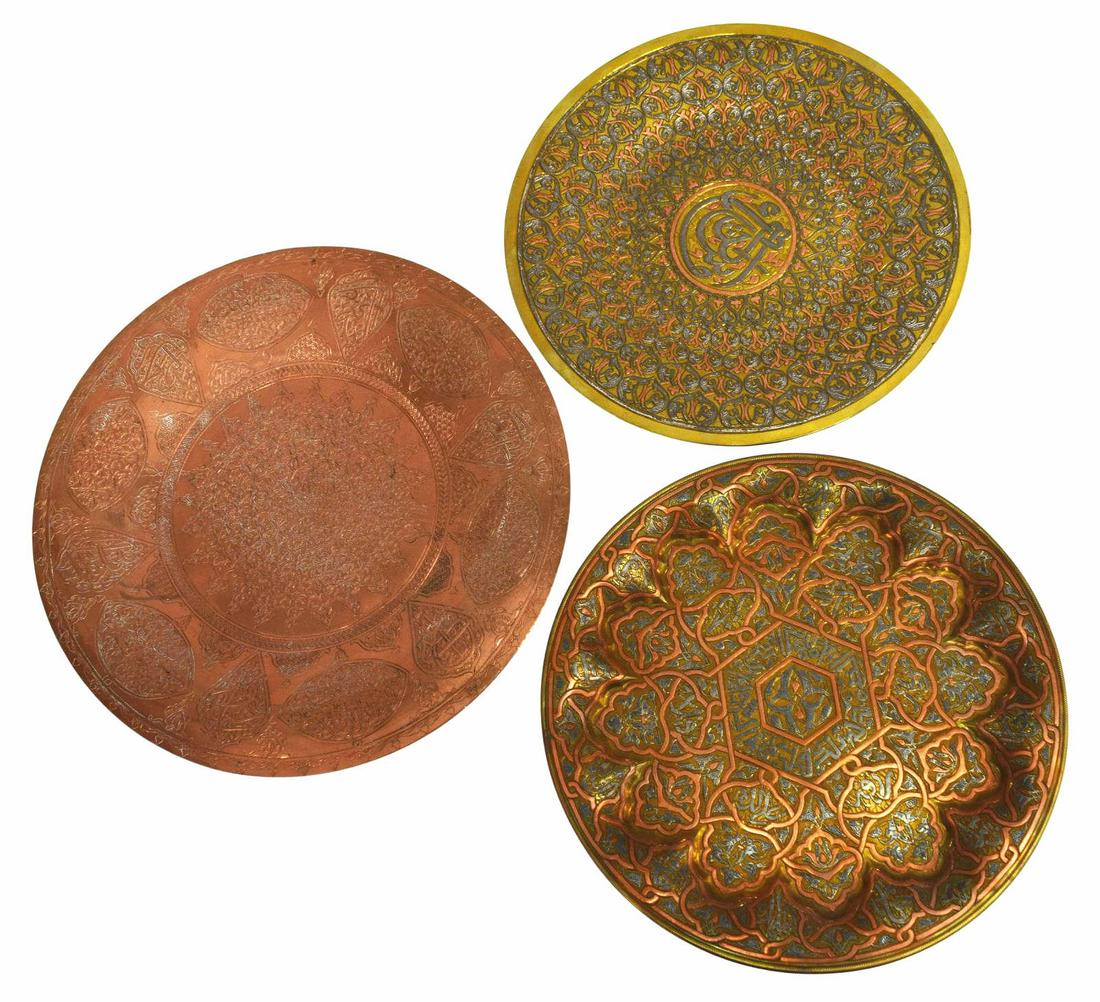 (3) ISLAMIC MIXED METAL BRASS & COPPER CHARGERS: (lot of 3) Islamic wall chargers, including: (2) brass with mixed metal inlays, (1) copper, each decorated with various arabesques and calligraphic motifs, picked out on a textured ground, largest: ap