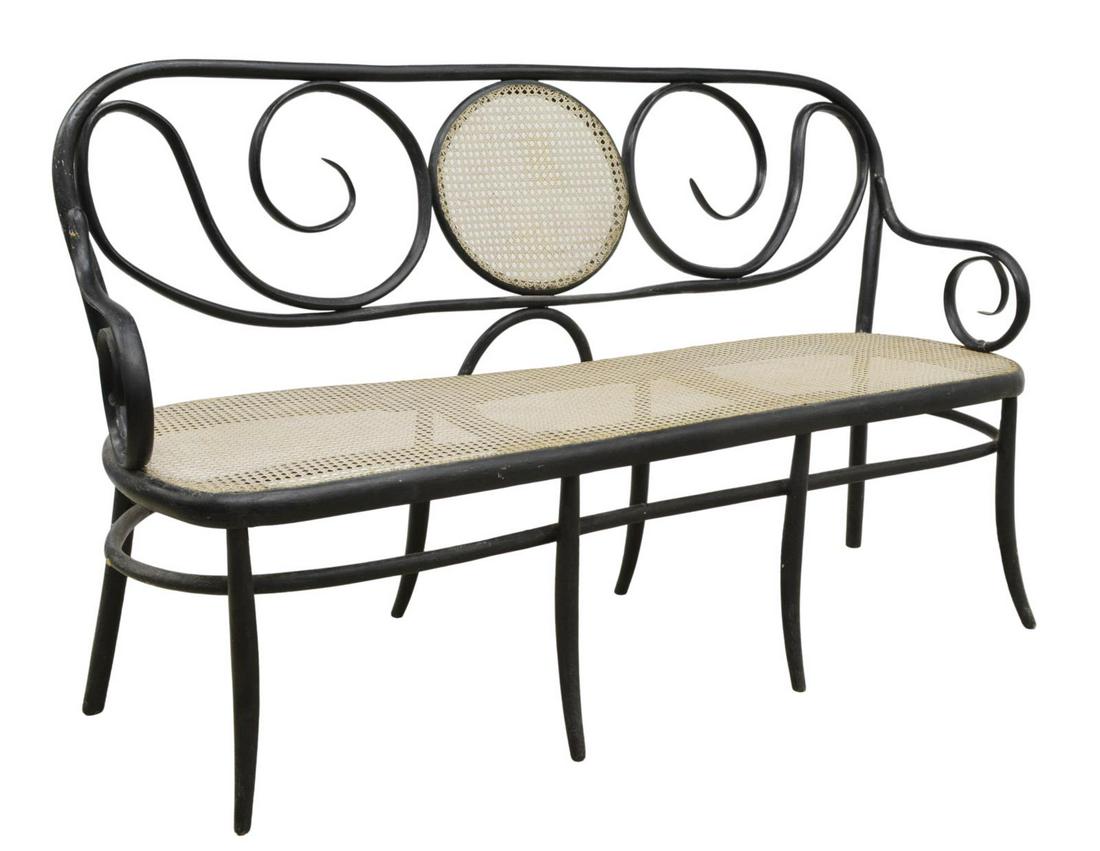 VIENNESE THONET STYLE BENTWOOD & CANE BENCH: Viennese bentwood bench, in the manner of Thonet, early 20th c., scrolled back with center cane medallion cane seat framed by scrolled arms, rising on stretcher-joined legs, approx 38"h, 62.75"w, 20.2