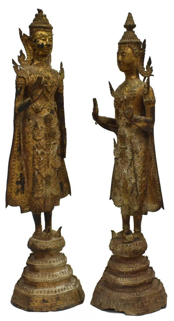 (2) THAI GILT BRONZE ABHAYA MUDRA BUDDHIST FIGURES: (lot of 2) Thai gilt bronze Buddhist figures, in headdresses and elaborate ceremonial costumes, (one) posed in Abhaya Mudra, (one) in double Abhaya Mudra, standing on a stepped base, largest: approx 2