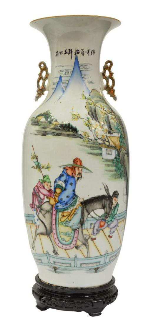 CHINESE PORCELAIN BALUSTER-FORM VASE: Chinese porcelain baluster-form vase, with gilt pierced handles, mountain landscape with figure on horseback, accompanied by two attendants, reverse with cursive script characters, on ebonized wood st