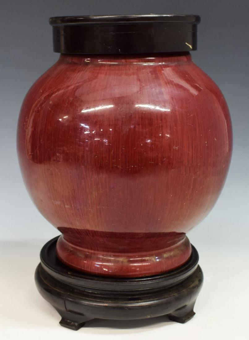 CHINESE SANG DE BOEUF GLAZED PORCELAIN COVERED JAR: Chinese porcelain covered jar, in sang de boeuf (oxblood) glaze, bulbous form, on wood stand, partial wax seal and script mark underfoot, crazing, possibly reduced rim, approx 13"h, 9"diam, 8.5lbs Sta
