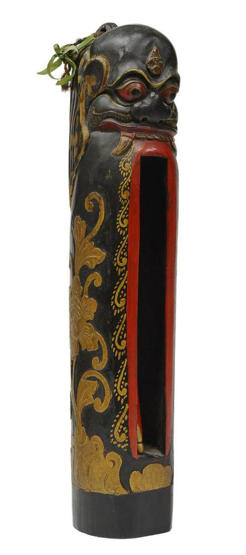 SOUTHEAST ASIAN CARVED & PAINTED WOOD SLIT DRUM: Southeast Asian carved wood slit drum, modeled a demon with open mouth, gilt lotus blossoms carved in relief, approx 16.75"h, 3 1/8"w, 3.5"d, 3.5lbs Start Price: $50.00