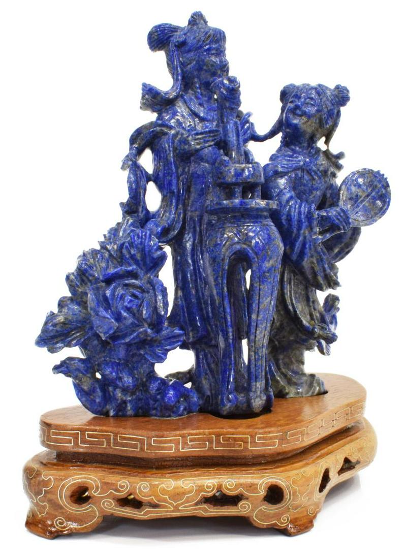CHINESE CARVED BLUE HARDSTONE FIGURE GROUP: Chinese carved blue hardstone figure group, lady and her attendant, one arranging flowers, the other with a fan, on fitted wood stand, approx 6.25"h, 5.25"w, 3"d, 1lbs Start Price: $80.00