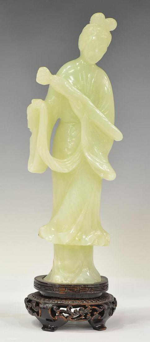 CHINESE CARVED PALE GREEN HARDSTONE GUANYIN: Chinese carved pale green hardstone female figure, likely Guanyin, holding a scepter or scroll, affixed to hardwood stand, approx 10"h, 3.25"w, 2.75"d, 1.5lbs **Provenance: From the estate of Ali A. A