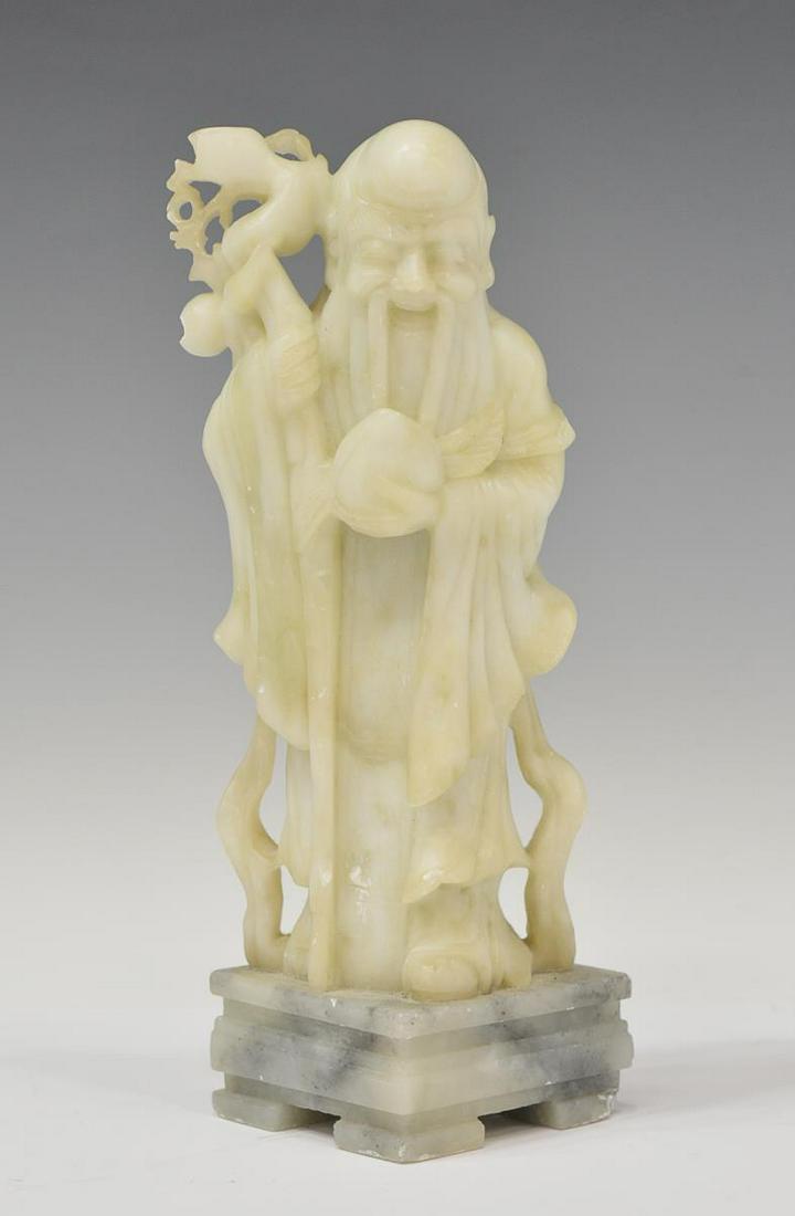 CHINESE SOAPSTONE SHOU LAO LONGEVITY FIGURE: Chinese soapstone longevity deity figure, Shou Lao, rising on an integral square base, chip to base, approx 9.5"h, 3.5"w, 3"d, 4lbs Start Price: $50.00