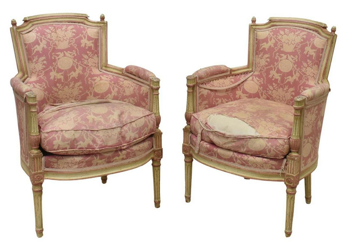 (2) FRENCH LOUIS XVI STYLE PAINTED BERGERES: (lot of 2) French Louis XVI style armchairs, early 20th c., white and pink painted frames, worn upholstery with cherubs and floral motifs, loose seat cushion, rising on tapered fluted legs, in need of