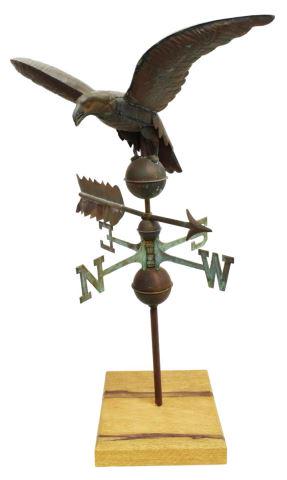 ANTIQUE PATINATED COPPER EAGLE WEATHER VANE: Antique patinated copper eagle weather vane, now mounted on a wood board, the eagle with 24" wing spread standing on a sphere, above an arrow and the steel compass direction indicator, overall: approx