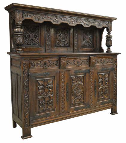 RENAISSANCE REVIVAL CARVED OAK COURT CUPBOARD: Renaissance Revival carved oak sideboard, late 19th c., molded cornice over carved frieze with shell and grapevine motifs, paneled backboard with carved foliates, center panel depicting knight in prof