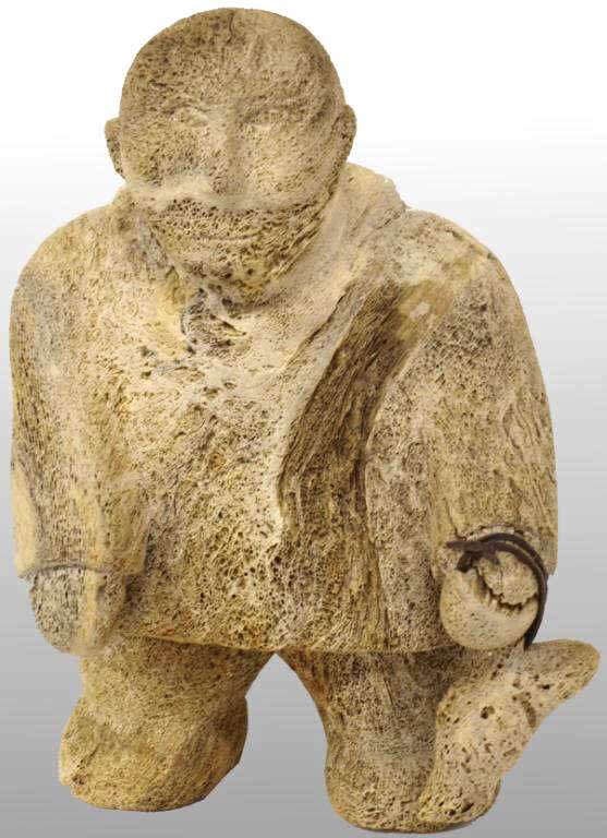 INUIT WHALE BONE SCULPTURE, ESKIMO HUNTER & SEAL: Large and unusual Inuit whale bone sculpture, by Jaypate Karpik, the figure carved as an Eskimo hunter carrying his catch, 18.5"h, 11.5"w, 9"d, 28lbs