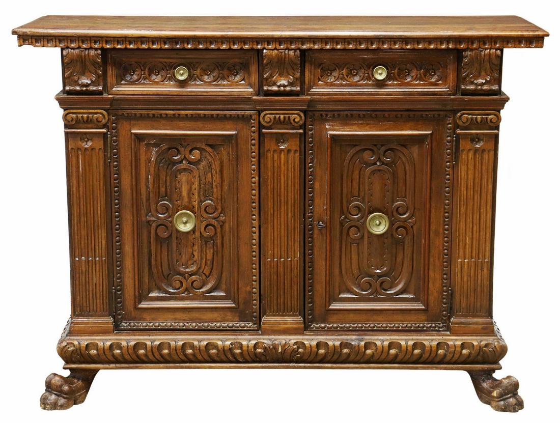 ITALIAN RENAISSANCE REVIVAL CARVED SIDEBOARD: Italian Renaissance Revival carved walnut sideboard, early 20th c., rectangular top with dentil molding, over case fitted with two drawers, above two cabinet doors opening to interior shelf, carved fo