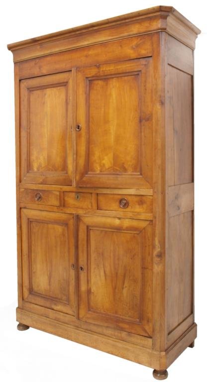 ANTIQUE FRENCH LOUIS PHILLIP CHERRYWOOD CUPBOARD: Unusual Louis Phillipe cherrywood cupboard, early 19th c., the ogee moulded cornice over a pair of upper and lower cupboard doors centered by a bank of three drawers, the middle drawer featuring a bra